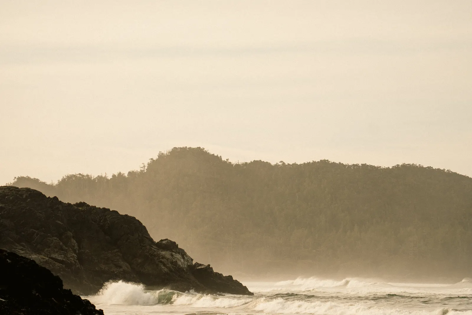 Misty forested headlands rising above calm water on the west coast near Tofino