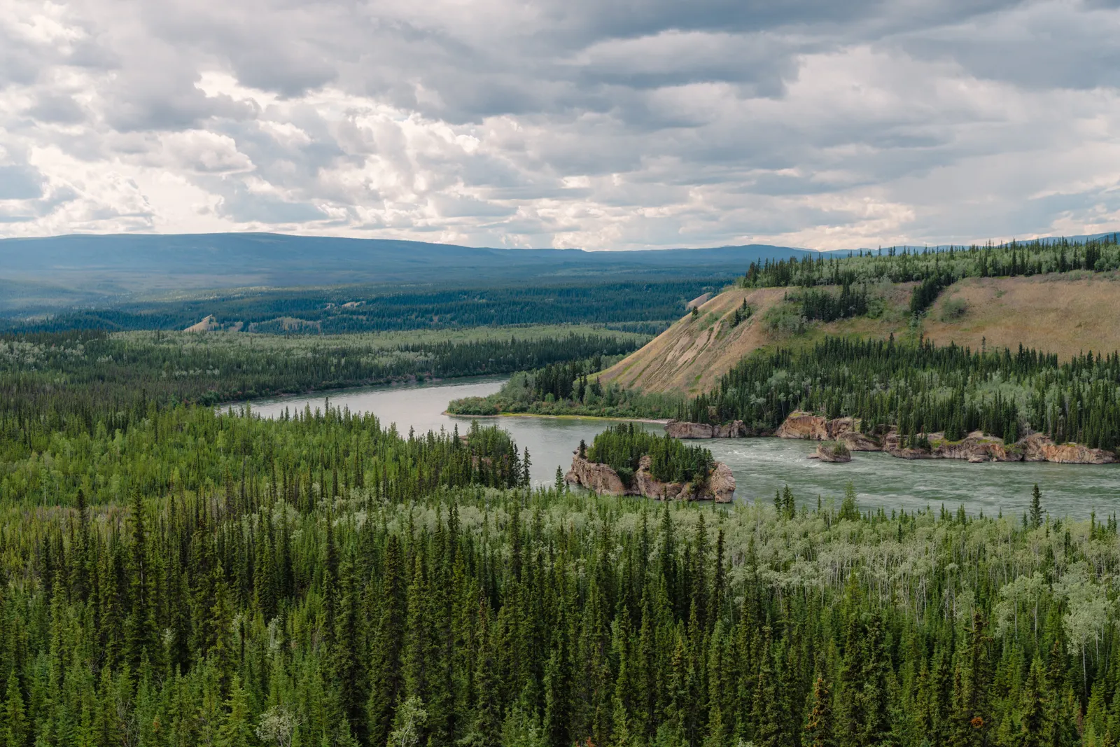 The Yukon River winding through a broad green valley under a wide sky